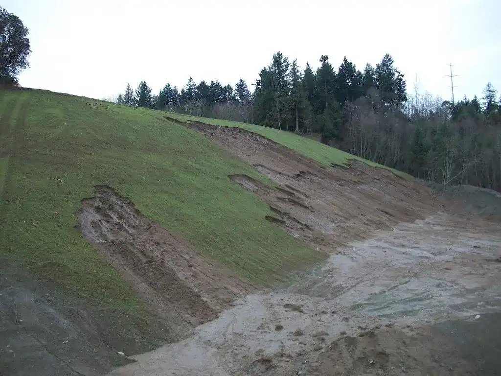 Failed grass seeding on gravel pit slope showing active erosion before bioengineering