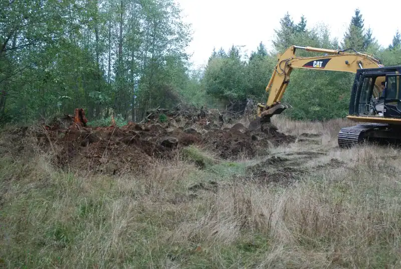 Excavator performing rough and loose surface treatment at Fort Shephard ecological restoration