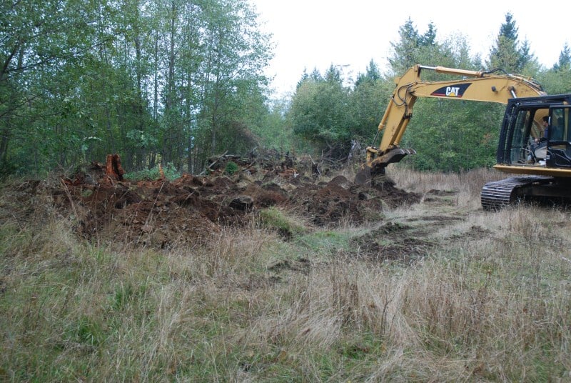 Excavator applying rough and loose treatment at Fort Shephard.
