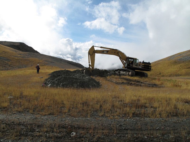 Excavator creating rough and loose topography on disturbed mine reclamation site